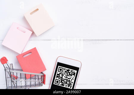 Abstract online shopping,mobile payment with QR code design concept element,colorful cart,paper bag on wooden table background,top view,flat lay Stock Photo