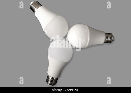 Three led bulb light and energy-saving lamp on table on gray background. Energy saving concept Stock Photo
