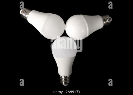 Three led bulb light and energy-saving lamp on table on black background. Energy saving concept Stock Photo