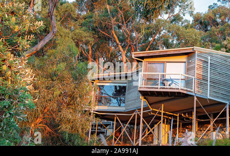 Triangle shaped rooms suspended on steel posts high amongst the natural bushland at a hotel resort in country Australia. Stock Photo