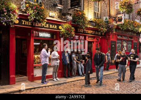 Outside the Temple Bar Irish pub in the famous neighborhood of the same name in Dublin, Ireland, on a summer evening. Stock Photo