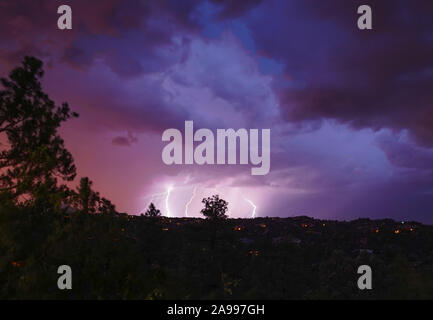 A monsoon lightning storm hits Arizona right after sunset, and accents the dramatic sky's colors. Stock Photo