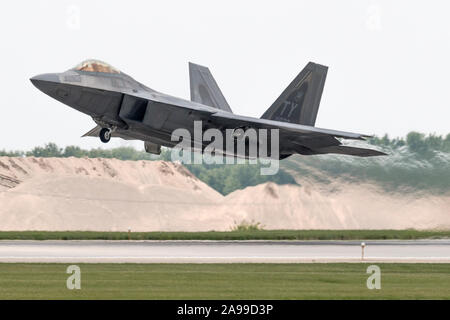 A Lockheed Martin F-22 Raptor performs a demo at the 2015 Rockford Airfest. Stock Photo