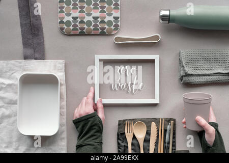 Frame with text 'Zero waste', top view, creative green concept of lunch kit. Flat lay, eco friendly takeaway lunch set - bamboo cutlery, lunch box, co Stock Photo