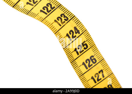 Close-up of a yellow measuring tape isolated on white - 125 - Selective focus Stock Photo