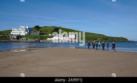 A group of wild swimmers enter the sea to swim around Burgh Island, Bigbury-on-Sea, Devon UK Stock Photo