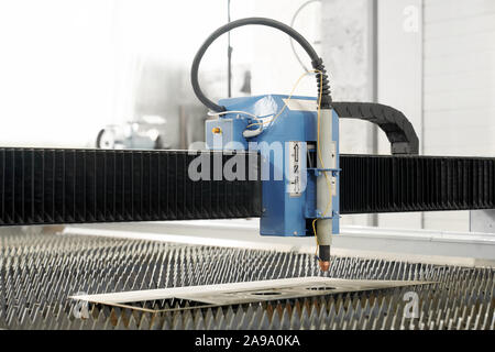 Front view of professional modern plasma cutter on metal factory. Automated machinery in process of cutting sheets and manufacturing. Concept of technology and engineering. Stock Photo