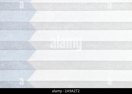 a white and grey striped textile fabric jalousie with a line of shadow  Stock Photo