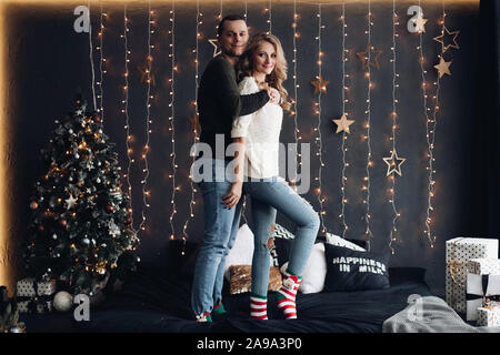 Smiling couple in decorated room for Christmas. Stock Photo