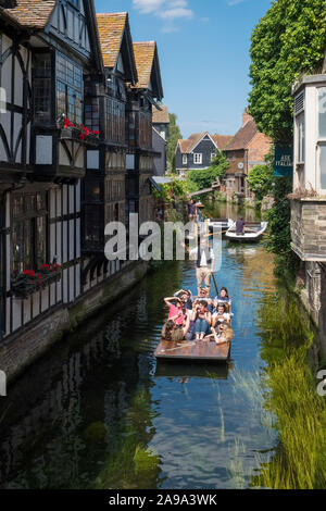 CANTERBURY, UK, - JULY, 11, 2019: Tourists enjoy a punt ride on the River Stour as they pass the 16th Century Old Weavers House in Canterbury, Kent, U Stock Photo