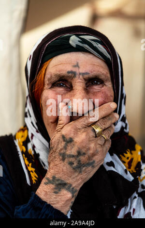 BADARASH, IRAQ - NOVEMBER 7 :  Erdahan, sits in front of her tent on the Bardarash refugee camp. Stock Photo