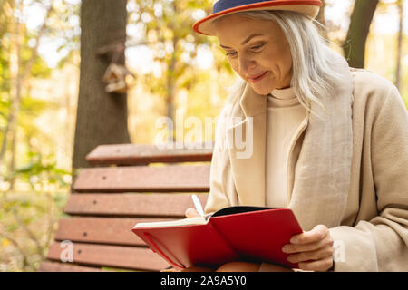 Stylish woman making notes in her notepad Stock Photo