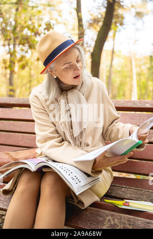 Motivated mature female student reading a textbook Stock Photo