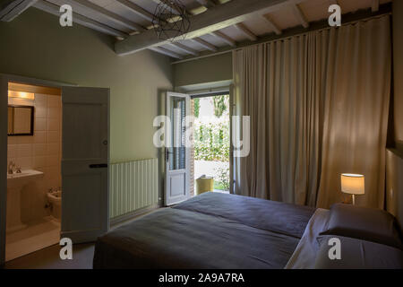 Interior view of a bedroom facing a garden in a rural country house in Chianti area, Tuscany, Italy Stock Photo