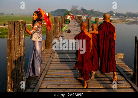 Buddhist Monks Crossing The U Bein Bridge, Amarapura, Mandalay, Myanmar. Stock Photo