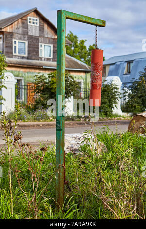 The fire market or bell is installed in a public place, on a rural street, designed to give an alarm in case of emergency and to alert the population Stock Photo