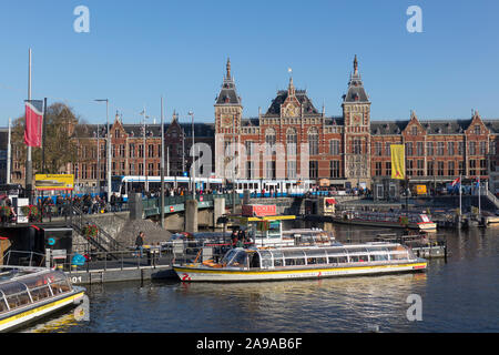 Amsterdam, Holland - October 30, 2019: Historical building of the Central Station at the Stationsplein near the Oudezijds Kolk water Stock Photo