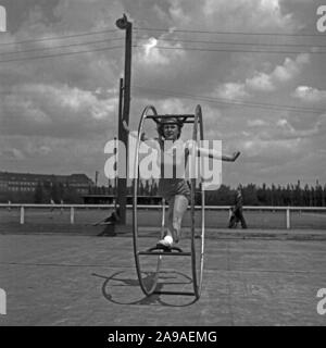 A young woman exercising with her gymwheel on a sporting ground, Germany 1930s. Stock Photo