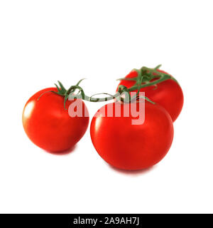 Three fresh tomatoes with green leaves isolated on a white background. red ripe heirloom tomatoes Stock Photo