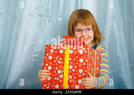 Girl Masha holding a box with a gift and smiling Stock Photo
