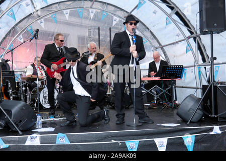 Colin Elsam alias “Joliet  Jake  Blues”, and Ricky Owen as  “Elwood  J Blues”, performing with the 5.0.5. Blues Band, at the 2019 Regents Street Motor Show Stock Photo