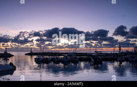 Sunrise and dramatic effect on the clouds at the marina in Cala Bona Majorca Stock Photo