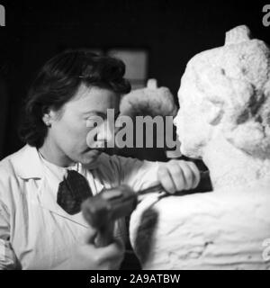 A sculptress working on a bust, Germany 1930s. Stock Photo