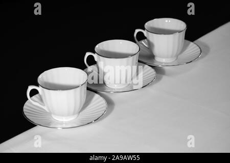 Three tea cups and saucers kept diagonally. Stock Photo