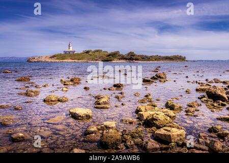 Alcudia lighthouse ( Faro De Alcanada) Located near Alcudia beach (playa de alcudia) and Alcudia Town. Small island with rocks in clear sea with beaut Stock Photo