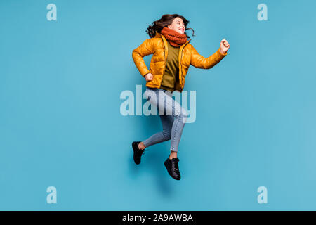Full length photo of crazy millennial lady jumping high running speed shopping season discounts wear stylish windbreaker jeans scarf pullover isolated Stock Photo
