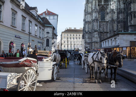 VIENNA, AUSTRIA - NOVEMBER 6, 2019: Fiaker, typical horse drawn carriages, standing in front of the Stephansplatz in downtown Vienna. These horse cabs Stock Photo