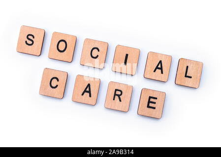 SOCIAL CARE, spelt with wooden letter tiles. Stock Photo
