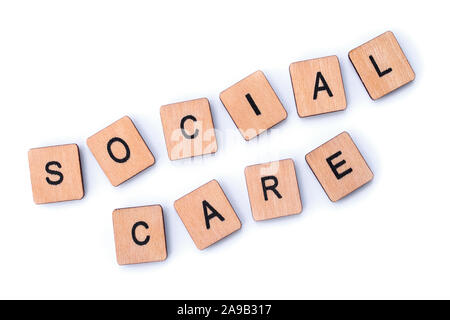 SOCIAL CARE, spelt with wooden letter tiles. Stock Photo
