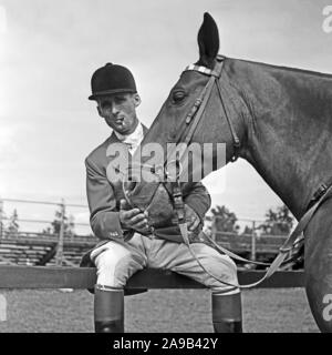 A young man wearing a jacket for an tournament in equestrian sports with is horse, Germany 1957 Stock Photo