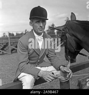 A young man wearing a jacket for an tournament in equestrian sports with is horse, Germany 1957 Stock Photo
