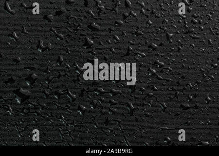 water drops on black flat rubber surface dark macro background Stock Photo
