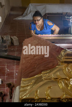 YUCATAN, MEXICO - OCT 22 2017. Restorer working on ancient frame. Mexican artist working on the restoration of an antique wooden frame Stock Photo