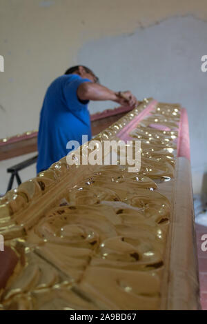 YUCATAN, MEXICO - OCT 22 2017. Restorer working on ancient frame. Mexican artist working on the restoration of an antique wooden frame Stock Photo