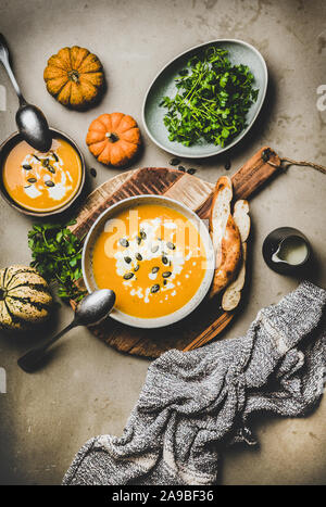 Flat-lay of pumpkin cream soup with seeds, parsley and bread Stock Photo