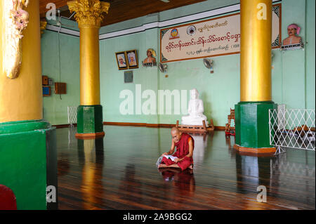 10.08.2013, Yangon, , Myanmar - A Buddhist monk sits on the floor in the temple area of the Shwedagon Pagoda and reads. 0SL130810D002CARO.JPG [MODEL R Stock Photo