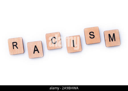 The word RACISM, spelt with wooden letter tiles over a white background. Stock Photo