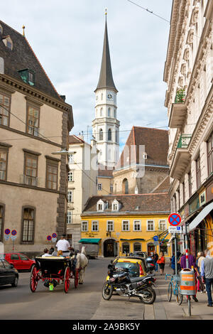 St Michael's Church (Michaelskirche) overlooking surrounding street of Stallburggasse with its shops, restaurants and coffee shops. Vienna Stock Photo