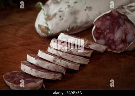 French dry sausage or saucisson. on cutting board ,close up. Stock Photo