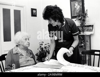 District nurse visiting elderly woman at home, Nottingham UK 1990 Stock Photo