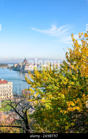 Autumn skyline of Budapest, Hungary with fall trees in the foreground. Hungarian Parliament Building, Orszaghaz, in the background on the other side of the Danube river. Hungarian capital city. Stock Photo