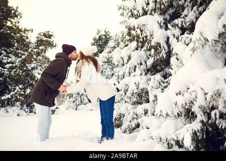 Man and woman kissing in snowy forest Stock Photo