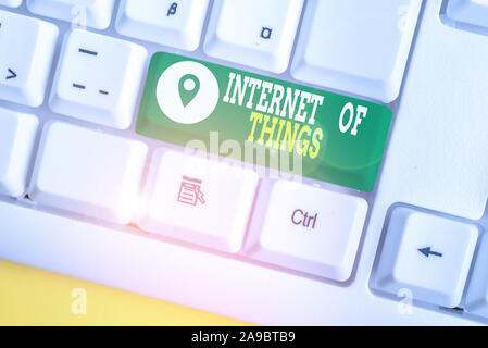 Writing note showing Internet Of Things. Business concept for connection of Devices to the Net to Send Receive Data White pc keyboard with note paper Stock Photo