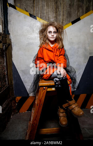 Ukraine, October 26, 2019:A full length portrait of a scary zombie girl standing near a bed. Halloween. Horror film. Stock Photo