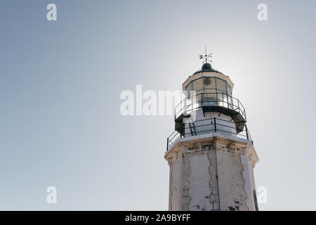 Close up low angle view of the exterior of Armenistis Lighthouse in Mykonos, Greece, against blue sky.