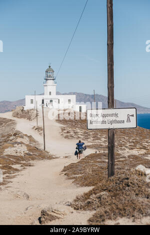 Mykonos, Greece - September 23, 2019: Sign on the approach to Armenistis Lighthouse in Mykonos, Greece, people walking on background. Lighthouse was b Stock Photo